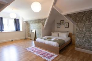 a bedroom with a large bed in a attic at Superb 4 BR Home in Leicester near Bus Stops in Leicester