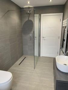 uma casa de banho com um chuveiro, um WC e um lavatório. em Luxury Canalside Apartment with Hot Tub em Poynton