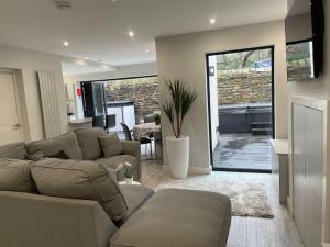 a living room with a couch and a table at Luxury Canalside Apartment with Hot Tub in Poynton