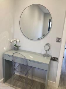 a dressing table with a mirror and a chair at Luxury Canalside Apartment with Hot Tub in Poynton