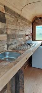 a kitchen with a sink and a wooden wall at Little Middop Farm Camping Pods in Gisburn