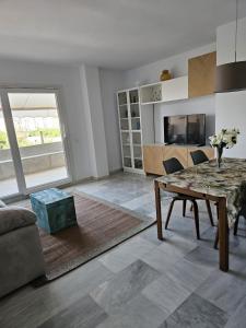 sala de estar con mesa y sofá en Ático Molière Beach en Málaga