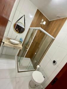 a bathroom with a sink and a toilet and a mirror at Pousada da Pedra in Pedra de Guaratiba