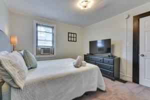 Schlafzimmer mit einem Bett, einem TV und einer Kommode in der Unterkunft Tonawanda Apartment Steps to Niagara River! in Tonawanda
