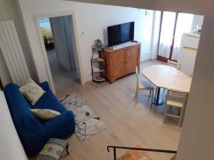 ein Wohnzimmer mit einem blauen Sofa und einem Tisch in der Unterkunft Costa del Sole 46 in Cetona