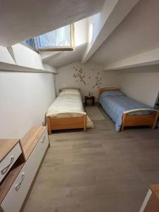 a attic bedroom with two beds and a window at Costa del Sole 46 in Cetona
