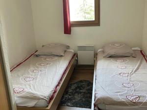two twin beds in a room with a window at Pied des pistes, balcon, 6 pers, parking, animaux admis - FR-1-557-121 in Les Adrets