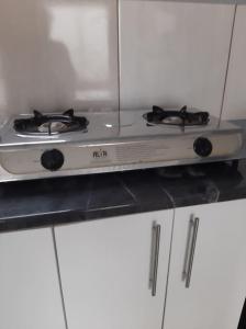 a stove top oven sitting on top of white cabinets at Sis-V's Inn in East London