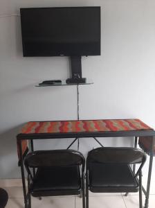a table with two chairs and a television on top at Sis-V's Inn in East London