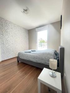 een slaapkamer met een bed, een tafel en een raam bij Vigneulle - 3 Chambres - 6P - Grand Balcon - Proche gare in Metz