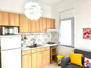 a kitchen with wooden cabinets and a white refrigerator at Sunny & Bright in Komotini