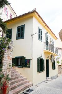a white house with green shutters and stairs at N1 Sokaki Apartment Nafplio in Nafplio