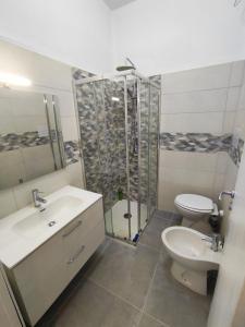 Un baño con ducha, lavabo e inodoro. en Kalura Sea Houses - private beach, en Cefalú