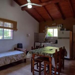 a living room with a table and a kitchen at Cabañas casanostra in Merlo