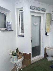 a bathroom with a toilet and a door to a beach house at Beach-Goretti House in Mairena del Aljarafe +21 photos