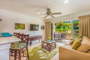 a living room with a couch and a table at 2 Bedroom Kapaa Condo with Pool and AC 115 in Kapaa