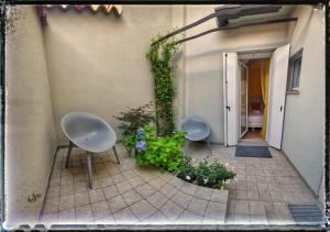 due sedie e piante sul lato di un edificio di ZONA 30 Bike Guesthouse a Palmanova