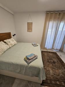 a bedroom with a bed with two towels on it at Ático Molière Beach in Málaga