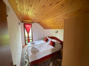 ein Schlafzimmer mit einem großen Bett und einer Holzdecke in der Unterkunft PURE NATURE in Visoko
