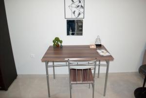 a wooden table and a chair in a room at Mina's Spacious Studio Apt : June '23 Renovated in Thessaloniki