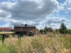 a house with a solar roof on top of a field at Eifelvilla zur Kirsche - Wellness und Spa in Burbach