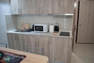 a small kitchen with a sink and a microwave at Mina's Spacious Studio Apt : June '23 Renovated in Thessaloniki