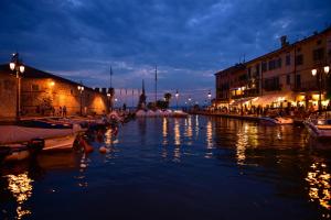 un grupo de barcos en un río por la noche en Appartamenti HERA, en Lazise