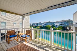 a balcony with two chairs and a table with a view of the water at Sunny Condo - Private Ocean Isle Beach Access! in Ocean Isle Beach