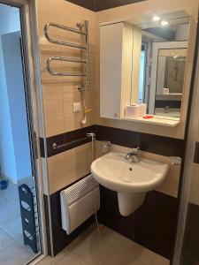 ein Bad mit einem Waschbecken und einem Spiegel in der Unterkunft Апартамент Панорама in Chissarja