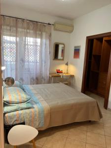 a bedroom with a bed and a chair and a window at Attico con terrazza in Via dei Traghetti in Lido di Ostia