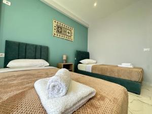 ein Schlafzimmer mit 2 Betten und Handtüchern darauf in der Unterkunft TreA Accomodations - Despacito Deluxe Sea View in Vlorë