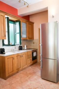 a kitchen with a stainless steel refrigerator and wooden cabinets at N1 Sokaki Apartment Nafplio in Nafplio