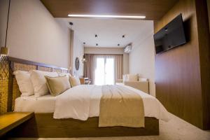 a bedroom with a large white bed with a window at Kasta Beach Hotel in Ofrínion