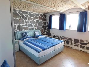a bedroom with a bed and a stone wall at Seelotsenstation Sassnitz mit Hafenblick by Unsere Urlaubszeit in Sassnitz