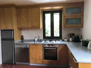 a kitchen with wooden cabinets and a black refrigerator at Recanto do Lameiro in Monção