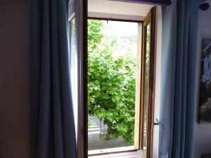 una ventana con vistas a un árbol en DÉDÉ DU VAL B&B, en Florac