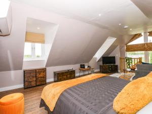 a attic bedroom with a bed and a tv at Strawberry Fields Annex in Wisbech