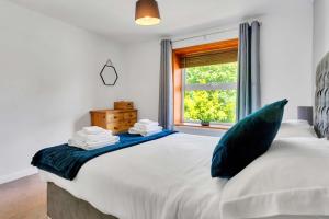 a bedroom with a large white bed with a window at The Retreat on Risbygate in Bury Saint Edmunds