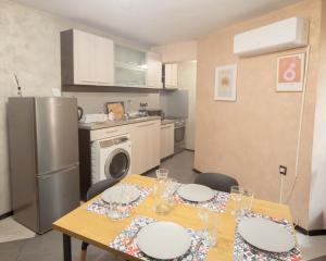 a kitchen with a table with plates and glasses on it at Aleks Holiday-center,sea,parking in Burgas City
