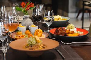 una mesa con platos de comida y copas de vino en BRUT by Slaviero Hotéis en Balneário Camboriú