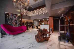 a living room with a pink couch and a chandelier at BRUT by Slaviero Hotéis in Balneário Camboriú