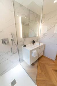 ein weißes Badezimmer mit einem Waschbecken und einem Spiegel in der Unterkunft Joli 3P vue mer Beausoleil, très proche Monaco in Beausoleil