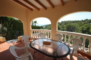 una sala da pranzo con tavolo e sedie sul balcone di Kanky 6 - modern, well-equipped villa with private pool in Benissa coast a Benissa