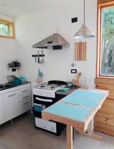 a kitchen with a stove and a table in it at Entre maitenes Bariloche in San Carlos de Bariloche