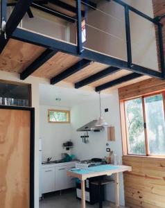 a kitchen with a table and a large ceiling at Entre maitenes Bariloche in San Carlos de Bariloche