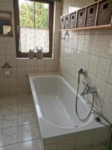 a white bath tub in a bathroom with a window at Gartenwohnung Paulsdorf in Dippoldiswalde