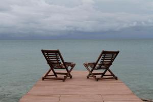 zwei Stühle auf einem Dock im Ozean in der Unterkunft Sal Si Puedes in Tintipan Island