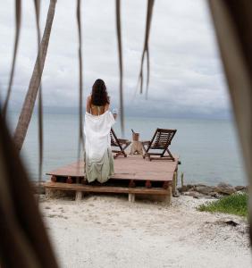 una mujer sentada en un banco en la playa en Sal Si Puedes, en Tintipan Island