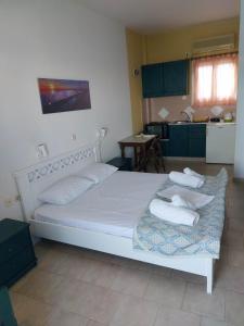 a bedroom with a large bed with towels on it at Aigaio studios & rooms in Azolimnos