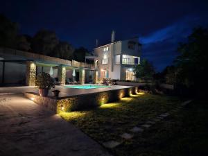 una casa con piscina por la noche en Villa Juliet en Kothoníkion
